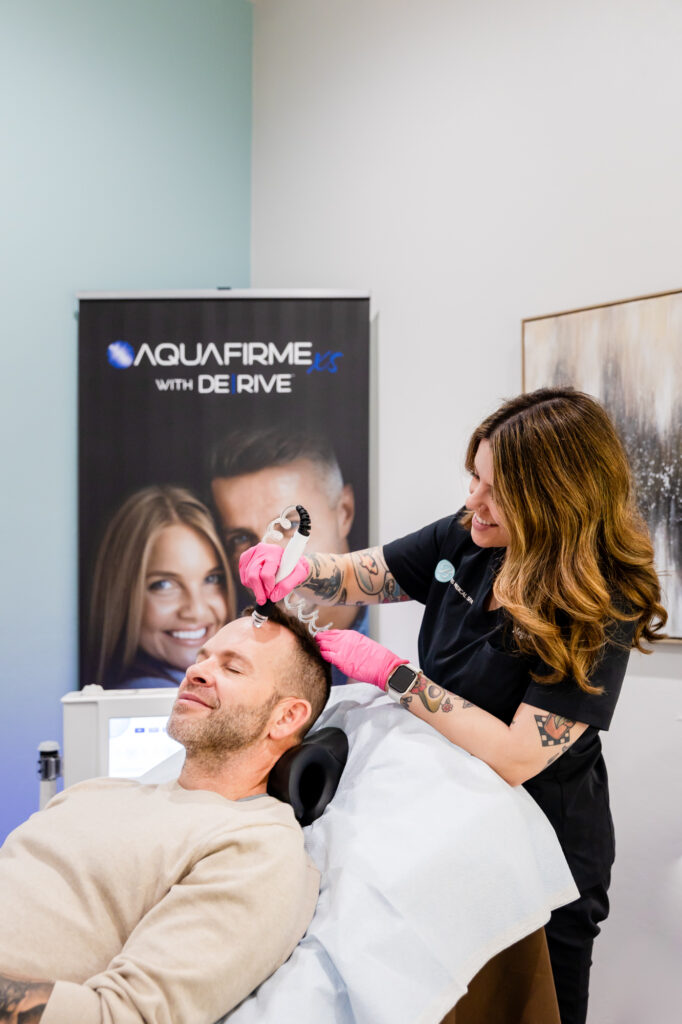 Man receiving treatment for hair restoration in Oklahoma City from professional wearing pink gloves